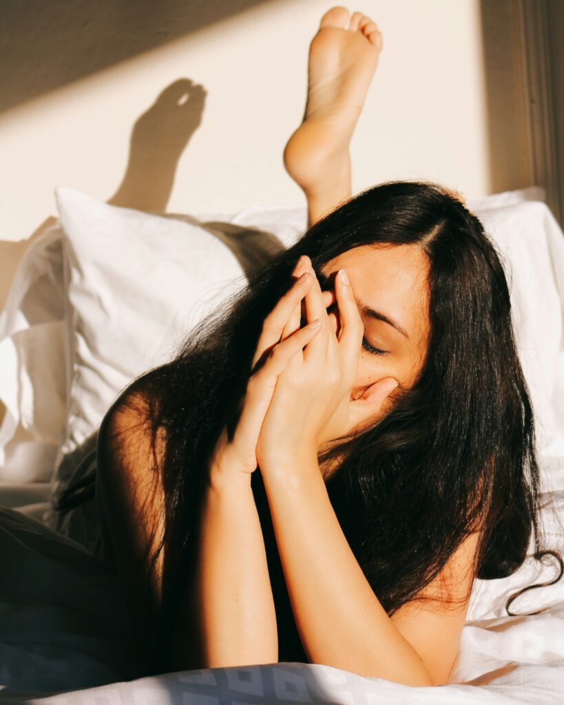 Person lying in bed showing emotional exhaustion and physical fatigue caused by chronic stress.