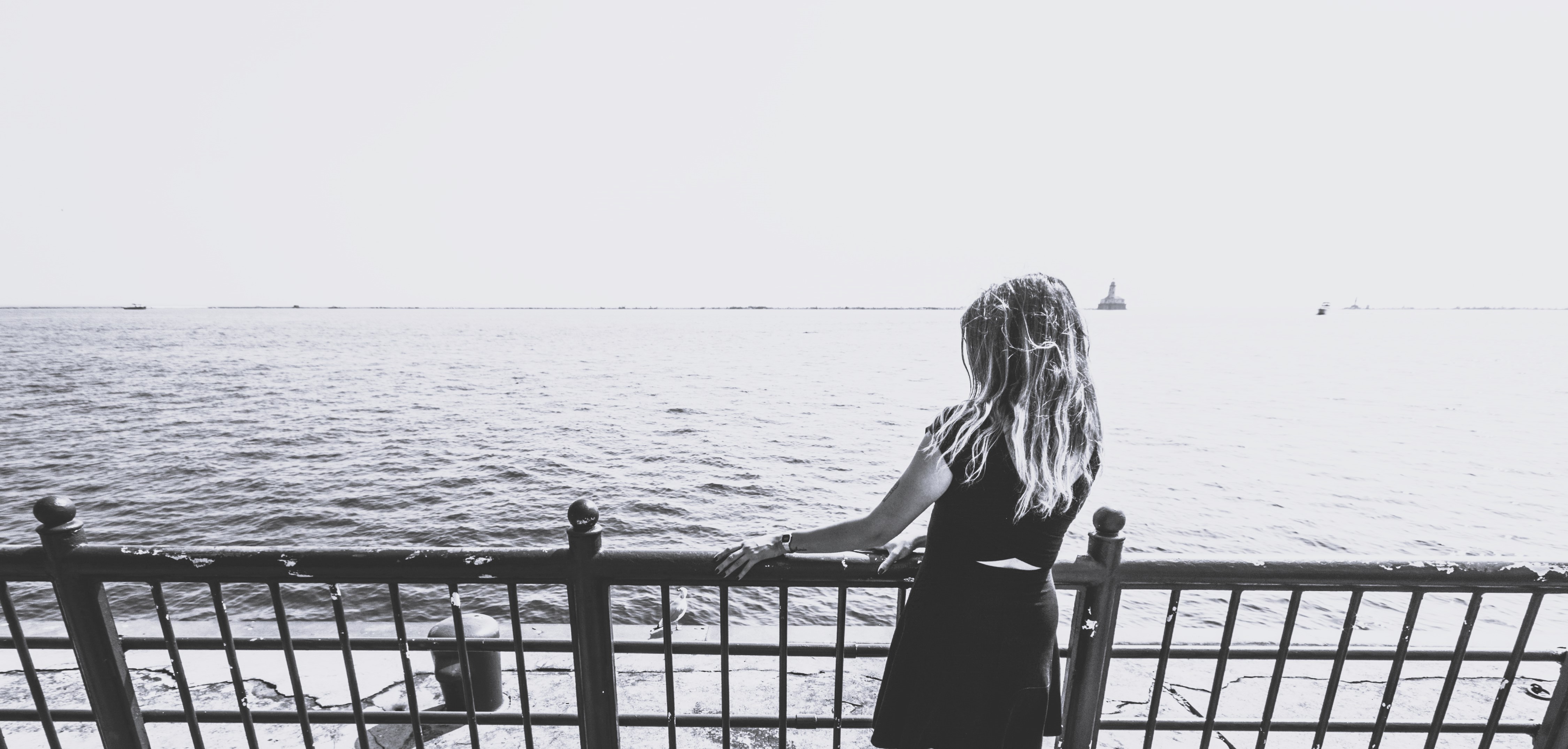 Woman feeling tired and overwhelmed, standing alone by the sea emotional exhaustion and low energy in women