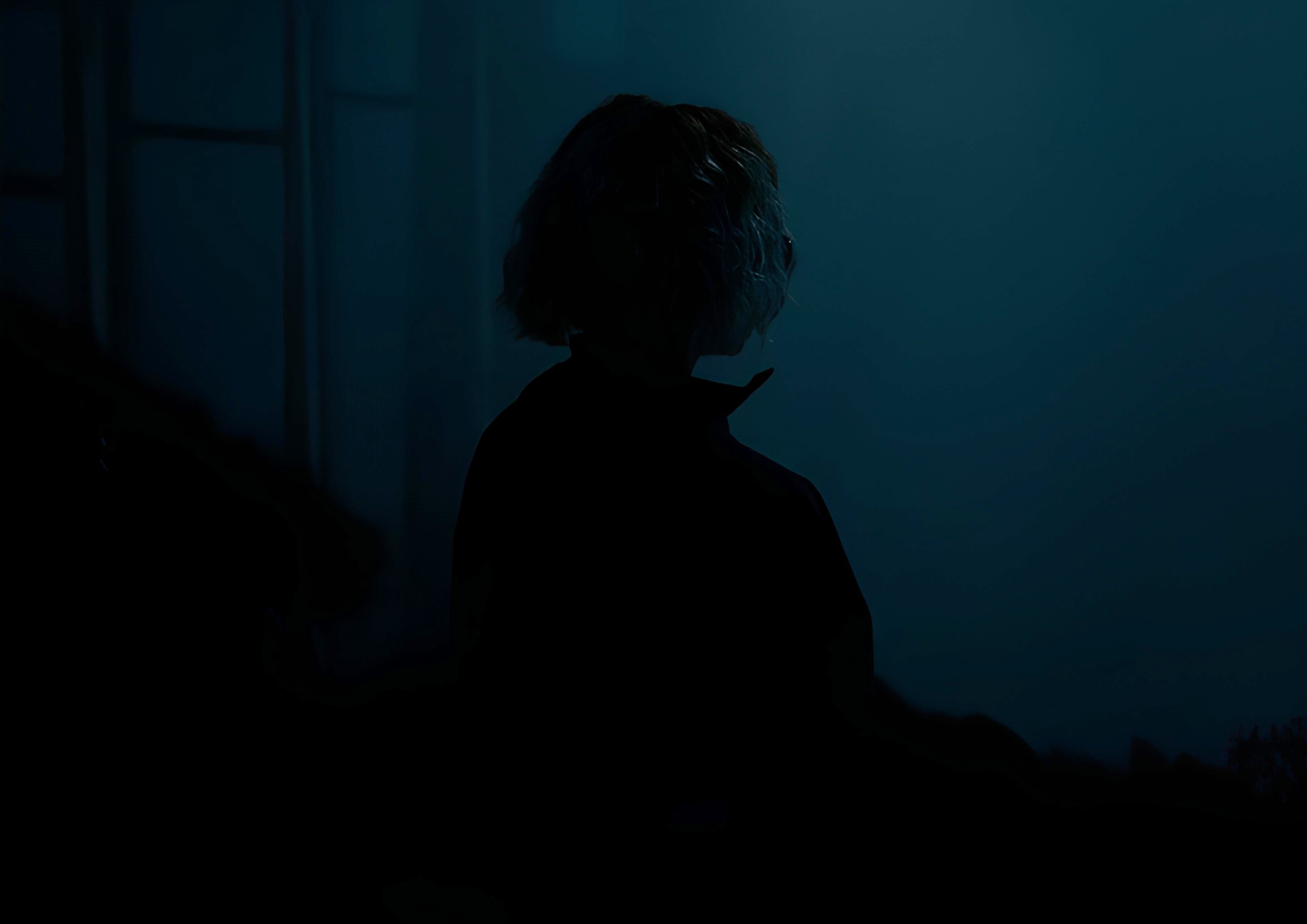 mentally exhausted but not lazy emotional fatigue conceptmentally exhausted person standing in dark room with light from window showing emotional and mental fatigue