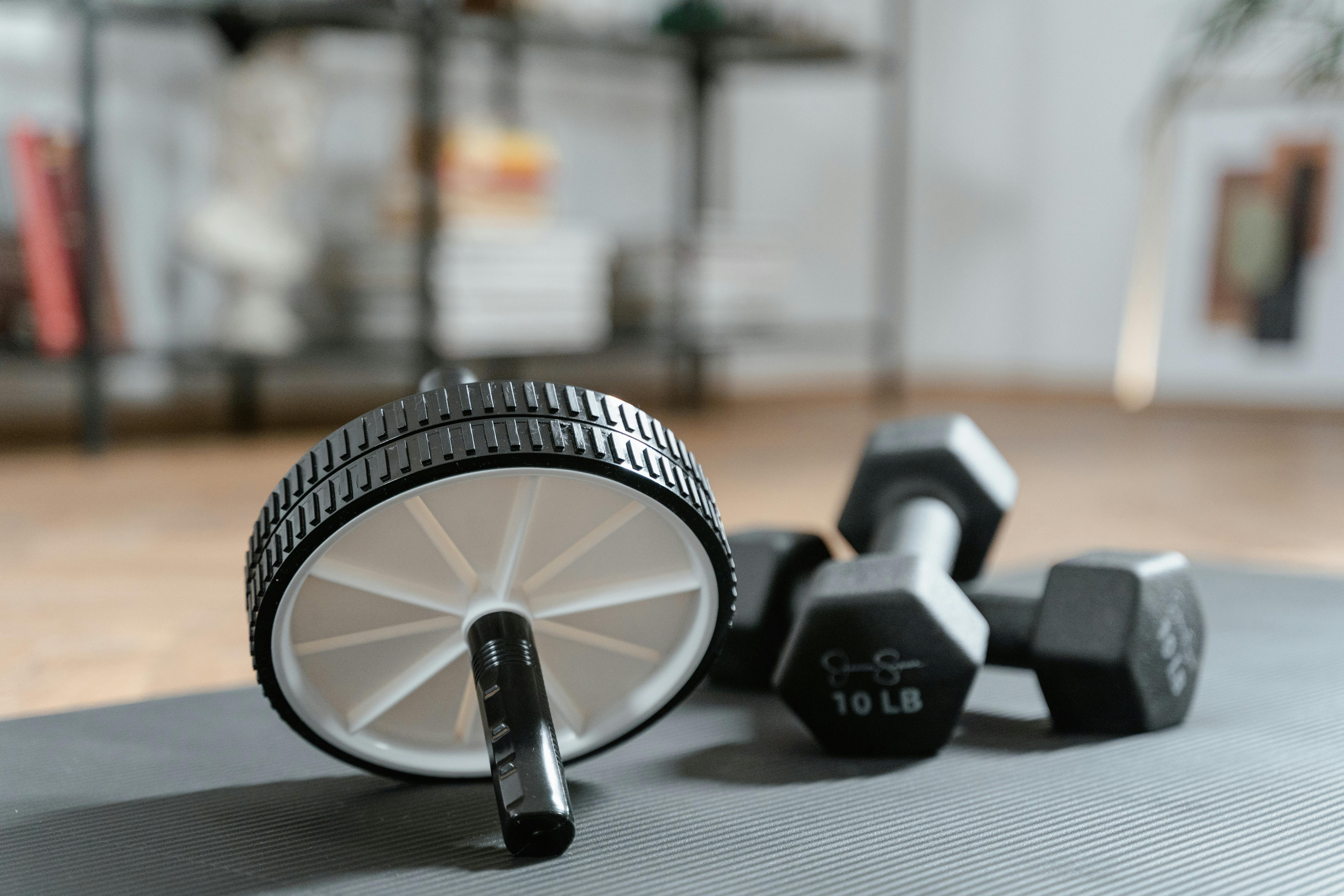 small fitness tools like ab roller and dumbbells for improving workout consistency at home