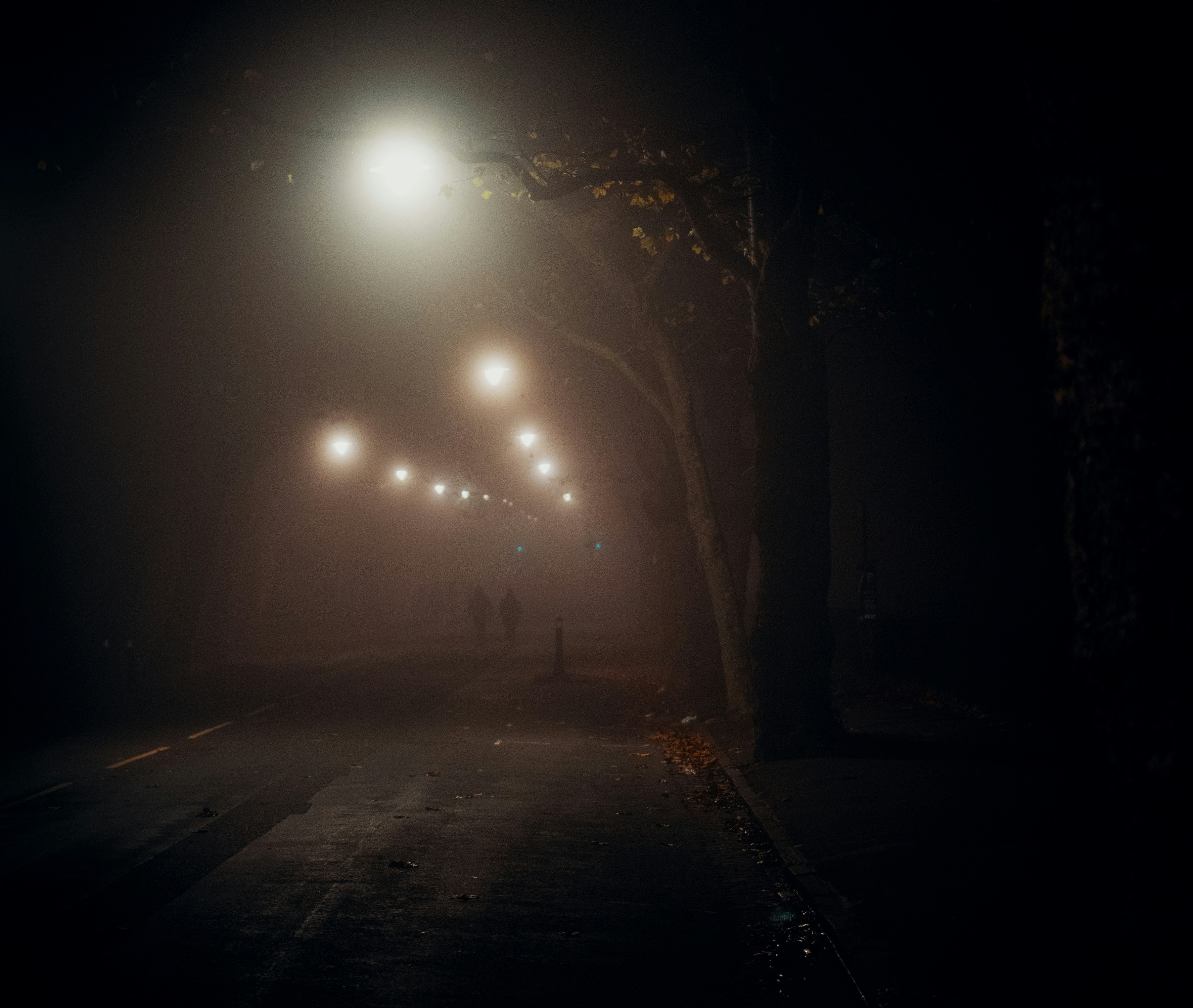 dark road with street lights symbolizing long term health consequences of skipping workouts