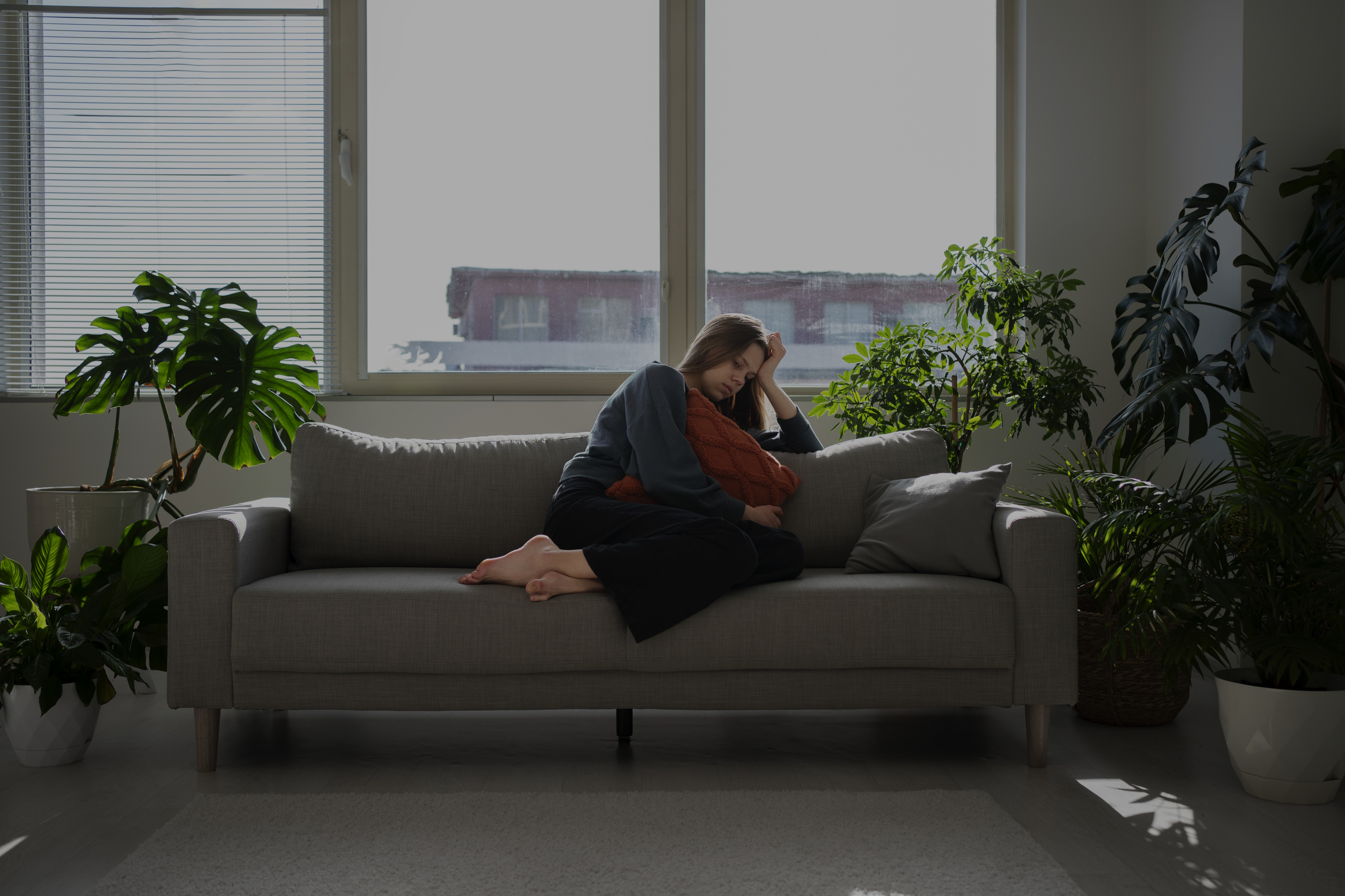 person sitting at desk with hands on head looking stressed and exhausted