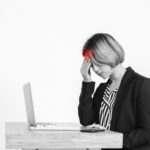person sitting at a desk all day looking puffy tired and drained with poor posture